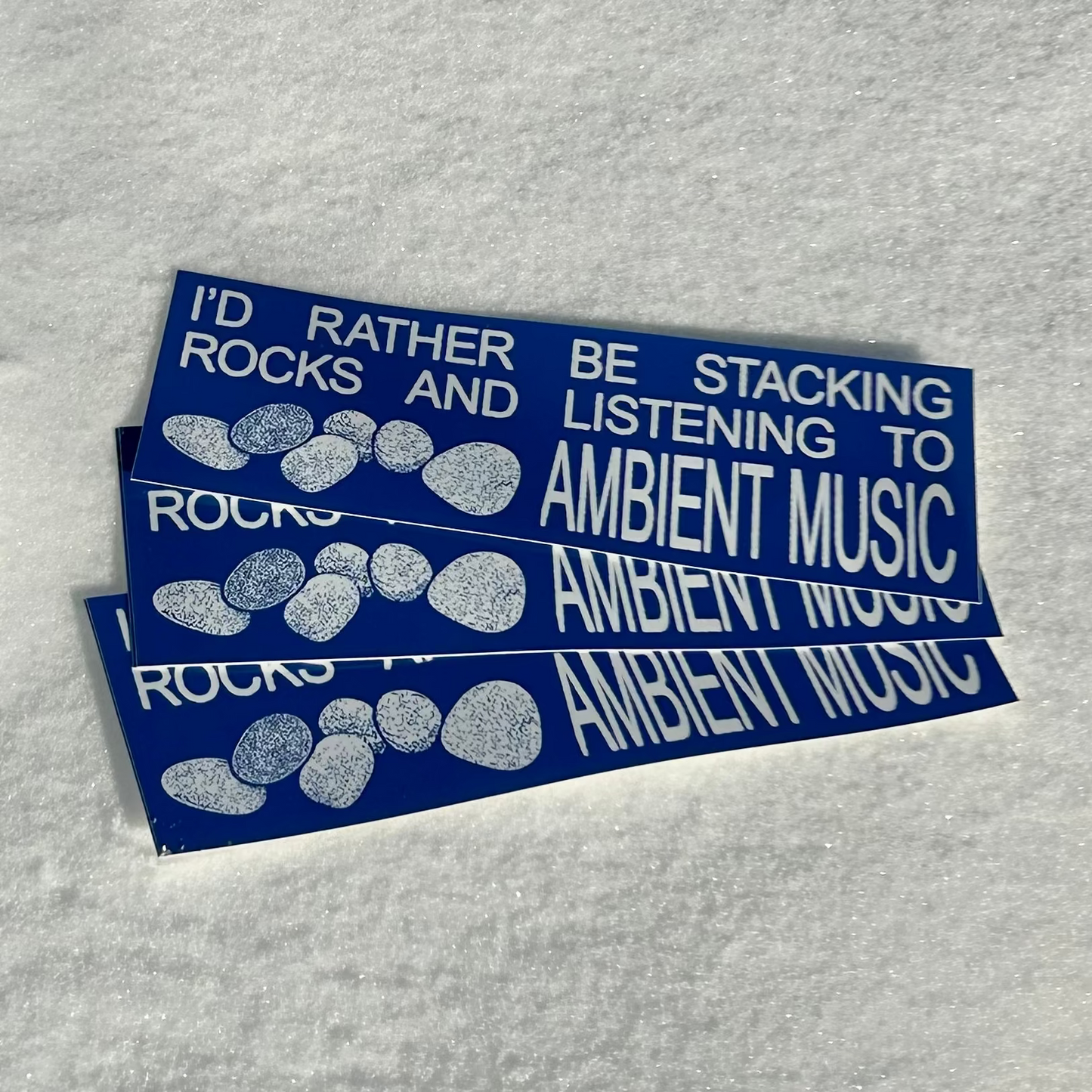 Three blue stickers with white text on a gray background
